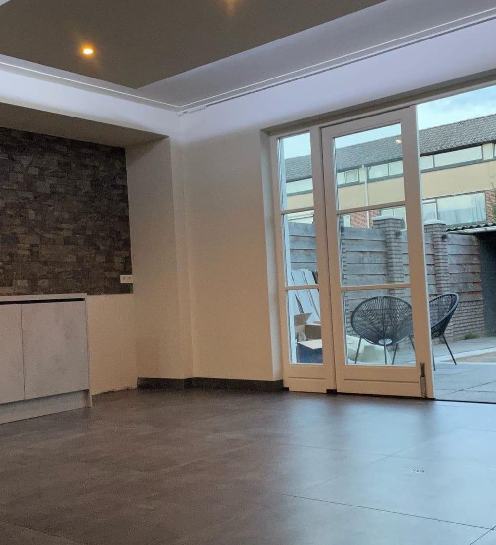Woonkamer met strak geschilderde wanden en plafond na binnenschilderwerk