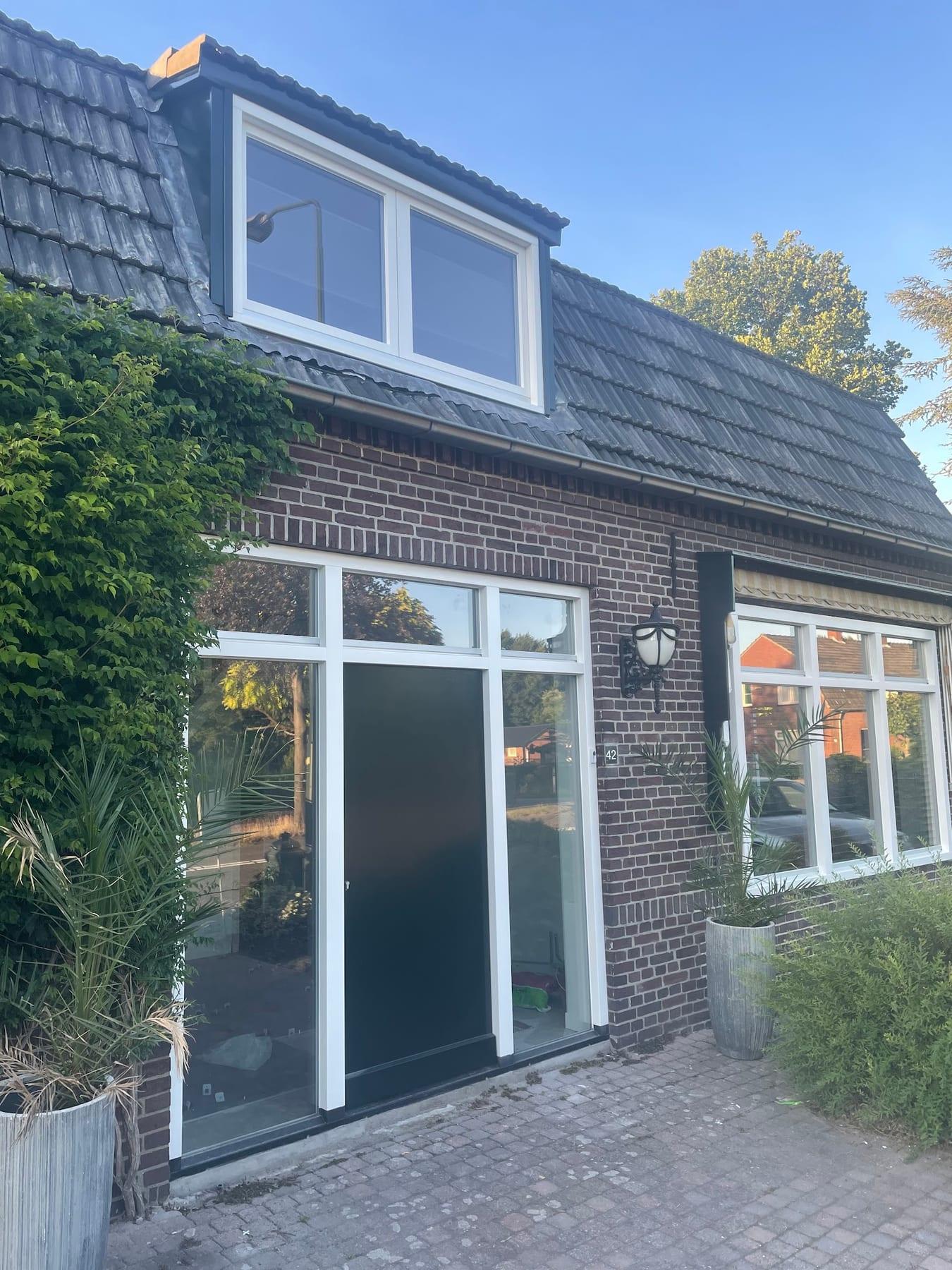 Wit gelakte kozijnen en deuren aan een bakstenen woning